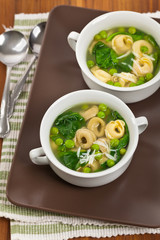 Tortellini Soup with Peas and Spinach. Selective focus.