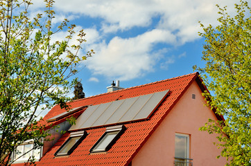 Solare Warmwassererzeugung auf rotem Hausdach