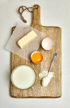 Ingredients for domestick baking on wooden board. white background. cooking concept