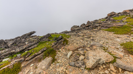 Rocky slopes in the mountains. Amazing view at the peaks which rose against the cloud sky. Path on the tops of mountains. MOUNT FREMONT LOOKOUT TRAIL, Sunrise Area, Mount Rainier