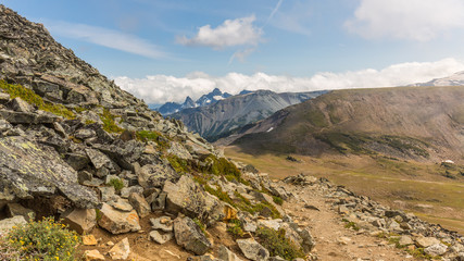 Rocky slopes in the mountains. Amazing view at the peaks which rose against the cloud sky. Path on the tops of mountains. MOUNT FREMONT LOOKOUT TRAIL, Sunrise Area, Mount Rainier