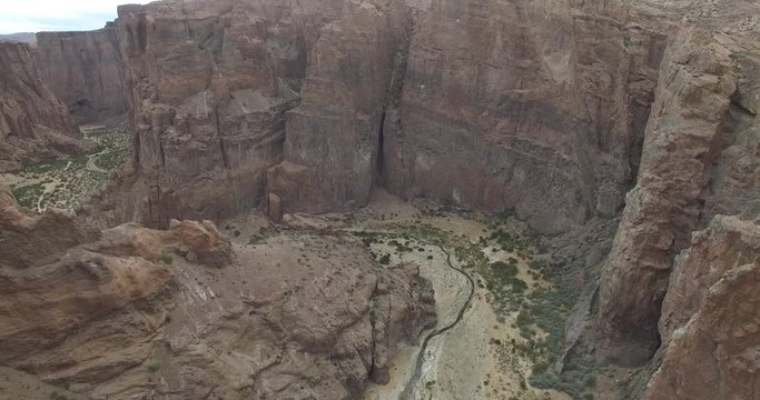 Aerial drone scene of Piedra Parada, a great canyon on Patagonia landscape, Argentina. Panoramic view of cliff, river. Camera moves to a higher altutide. Monumental natural landscape.