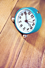 Old clock on the wooden background.