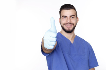 lächelnder Arzt mit Handschuhen zeigt mit dem Daumen nach oben