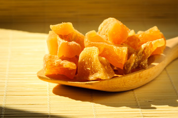 Closeup candied ginger on wooden spoon