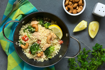 Couscous mit Brokkoli, Hähnchen, Tomate und Cashewnüssen, fotografiert mit natürlichem Licht