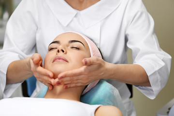 Obraz na płótnie Canvas Young woman having face massage in a beauty salon