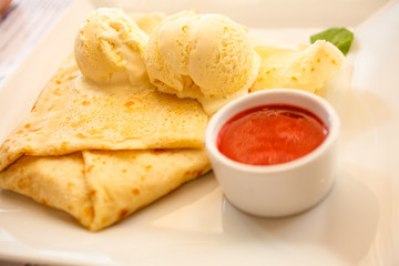 Pancake with ice cream and strawberry sauce