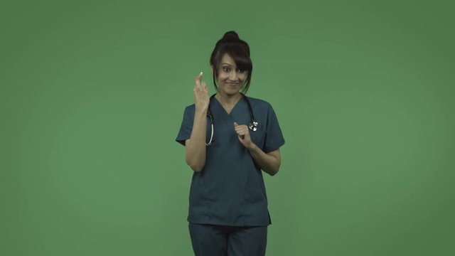 indian female doctor with fingers crossed isolated on greenscreen