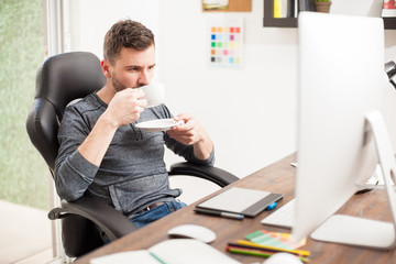 Drinking coffee in front of a computer