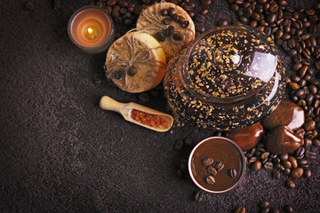 Composition of soap, chocolate in bowl and coffee beans on brown towel background