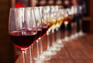 Many glasses of different wine in a row on bar counter