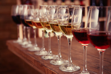 Many glasses of different wine in a row on bar counter
