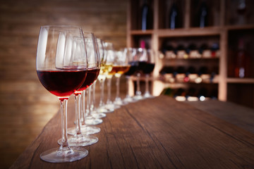 Many glasses of different wine in a row on bar counter