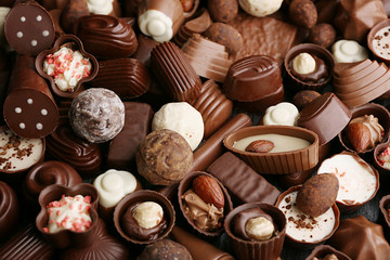 Assortment of delicious chocolate candies background, close up