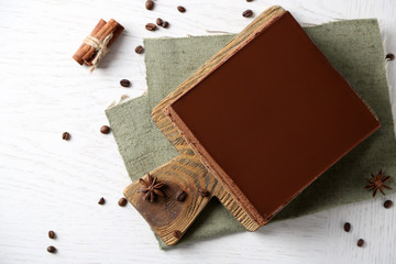 Delicious chocolate cake on wooden cutting board closeup
