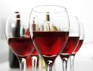 Glasses of red wine on white table closeup