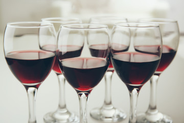 Glasses of red wine on white table closeup