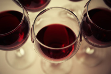 Glasses of red wine on white table closeup