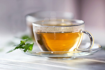 Cup of tea with mint on wooden table