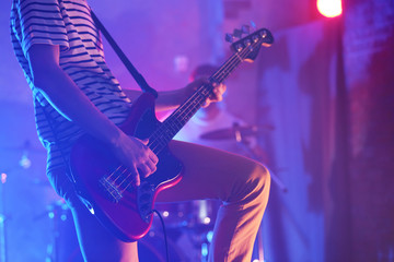 Fototapeta na wymiar Man playing electric guitar on a stage.