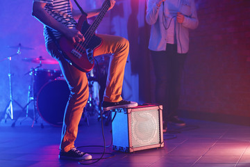 Man playing electric guitar on a stage.