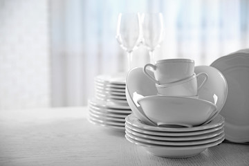 Set of new white dishes on wooden table, indoors