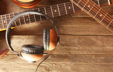 Fototapeta na wymiar Guitars and headphones on wooden background