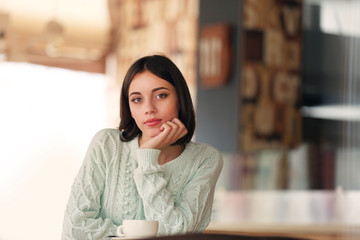 Young woman drinking coffee in cafe