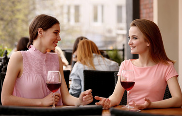 Young women drinking wine in cafe