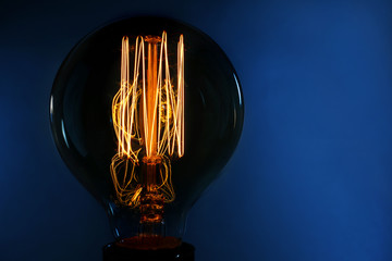 Illuminated light bulb on dark blue background