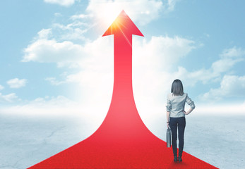 businesswoman standing on a red arrow