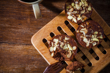 Homemade delicious fresh chocolate and almonds cake on wooden ta