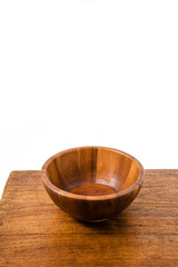 Empty wooden bowl on wooden background.