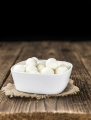 Small Mozzarella balls (on wooden background)