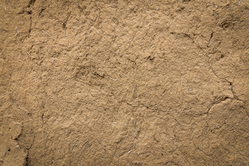 Old clay wall with cracks background.