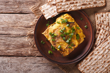 Matzah brei with green onions close-up on a plate. horizontal top view
