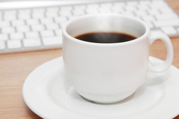 cup of coffee in front of keyboard