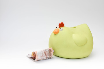 Yellow chicken piggy bank and money  on white background