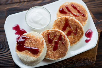 Closeup of cottage cheese pancakes with sour cream and jam