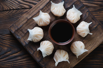 Dim sum dumplings on a rustic wooden serving board, top view