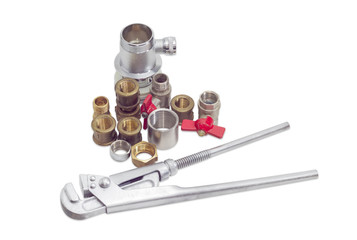 Plumber wrench and several plumbing components on a light backgr