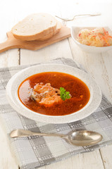 hungarian fish soup in a soup plate, salad and bread