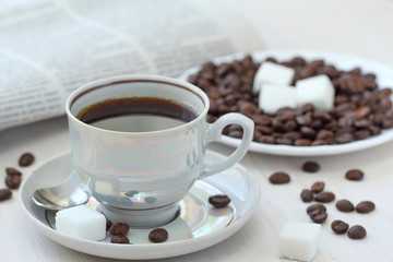 Cup of black coffee and newspapper