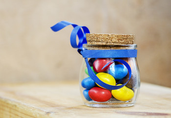 colorful candies jelly beans in a jar tied with a blue ribbon