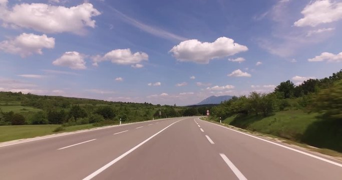 Driving A Car - Pov - Country Road clouds and greeen nature. POV Car driving on an empty two lane highway on Balkan route on a cloudy day