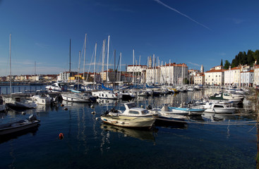 Fototapeta premium PIRAN, SLOVENIA - APRIL 16, 2016: Motorboats and yachts moored in Marina of coastal town. With narrow streets and compact houses Piran is a town in southwestern Slovenia on the Adriatic Sea