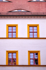 vintage building facade with four orange framed windows