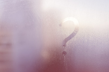 Question mark. Inscription concept drawing on fogged window glass background closeup