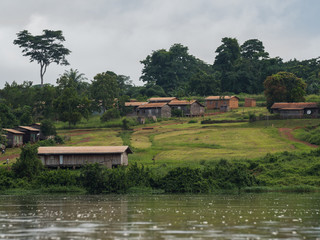 A small African village is situated on the green shores of the river Sangha (Nouabal-Ndoki National Park, Republic of the Congo)